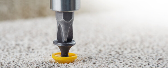 screwdriver screw and dowel in a concrete wall background