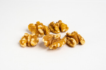 Raw heap of raw organic walnut kernels close up on a neutral background