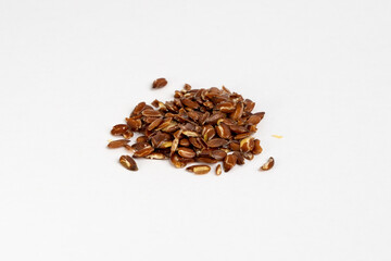 Heap of kibbled raw organic linseeds organic close up detail on neutral background