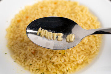 Alphabet soup letters with Hartz IV on the spoon, instant easy fast food because of poverty