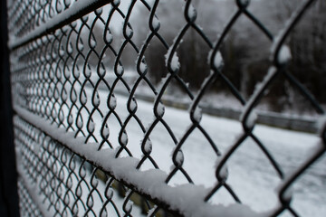 A chain-link fence that is frozen and snowed in