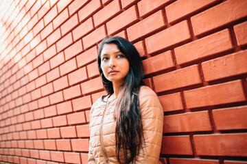 portrait of a woman against brick wall