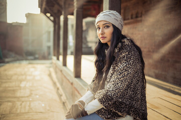 Beautiful young women standing over old style wall background.
