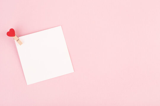blank white Valentine's day card on pink background, top view