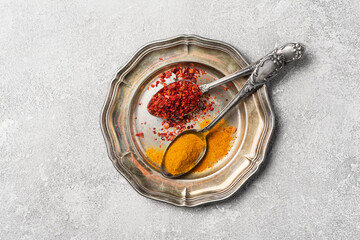 Red pepper and turmeric spices in vintage spoons for tasty meals