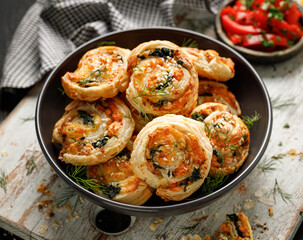 Puff Pastry Pinwheels stuffed with salmon, cheese and spinach in a bowl close up - 402581856