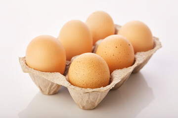 Brown eggs in egg box on white background.