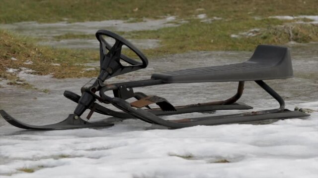 Snow racer kids toy for winter fun. Kids toboggan at the bottom of a hill in the winter time. Close up sled for winter fun. Children's toy. 