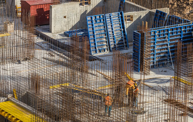 Construction workers install formwork and iron rebars or reinforcing bar for reinforced concrete...