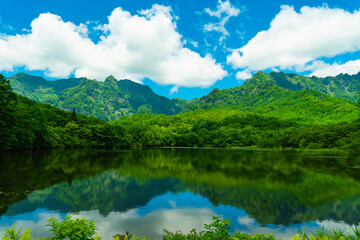 Fototapeta na wymiar 新緑の山々が映る鏡池・長野県戸隠高原