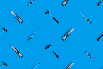 Tools seamless pattern. Tools: hammer, screwdriver and knife on a blue background.