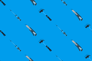 Tools seamless pattern. Tools: hammer, screwdriver and knife on a blue background.