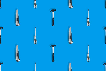 Tools seamless pattern. Tools: hammer, screwdriver and knife on a blue background.