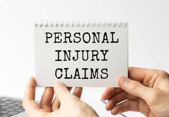 Businessman holding a card with text PERSONAL INJURY CLAIMS.