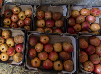 Ripe pomegranates lying in cardboard boxes on the street