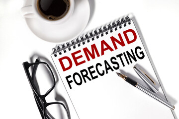 DEMAND FORECASTING, text on white paper on a white background near a CUP OF COFFEE