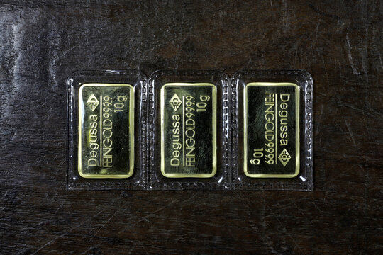 sealed 10 grams Degussa gold ingots on wooden background