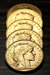 French 20 Francs gold coins (obverse with Marianne) on rustic wooden background