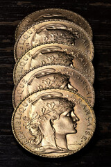 French 20 Francs gold coins (obverse with Marianne) on rustic wooden background