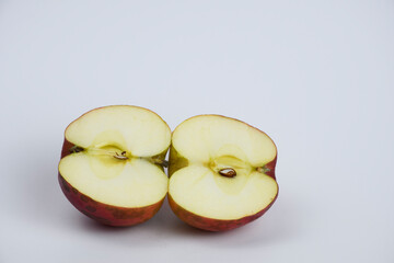 Red apple cut in half. Two pieces of fruit. Isolated on white background.