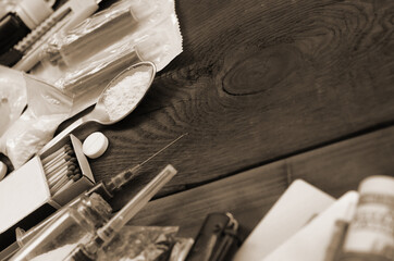 A lot of narcotic substances and devices for the preparation of drugs lie on an old wooden table