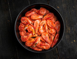 Raw Northern shrimps or prawns in a frying pan . Top view