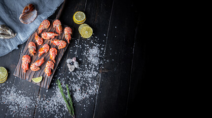 Raw Greenland shrimps or prawns on wooden cutting board . Top View with Copy space. 