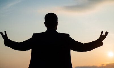 personal achievement goal. man silhouette on sky background. confident businessman with raised...