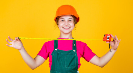 This will be perfect. kid wear helmet on construction site. teen girl builder with building tool tape measure. child on repairing work. concept of renovation in workshop. busy professional carpenter