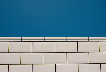 Background of the white ceramic tiles on blue wall in the bathroom. Installing Stone Glass Mosaic Tile. 
