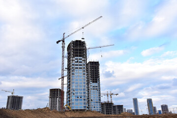 View of a larger construction site where tower cranes are new building residential buildings, multi-storey offices and modern skyscrapers. Preparing to pour of concrete into formwork