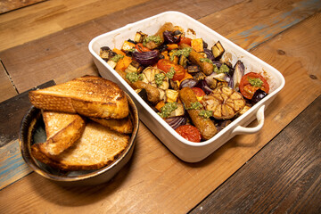 A baking trey of sausages and vegetables with tarragon relish