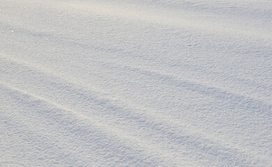 Close up of white snow background. Snow covered ground on a frosty winter day. The concept of colds and blizzards. Frozen river or lake, pure tone texture