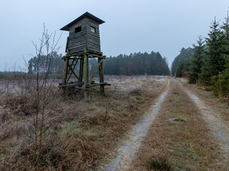 A wooden hunting pulpit at the edge of the forest. A place for hunters intended for hunting hunting. Winter season.
