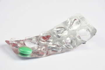 Package of empty plastic foils. Close-up empty blister pack with one green pill left.