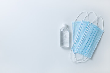 Medical protective, blue face masks, sanitizer gel, on white background, close-up, flatly, minimal style, copy space. Hygiene concept, protective equipment, prevention of spread of viral infections