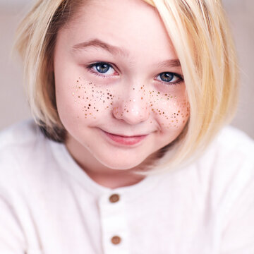 portrait of beautiful androgynous boy with golden freckles and blonde hair