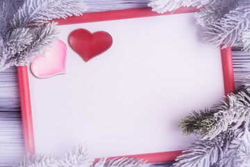 Blank white card with red frame, two Valentines hearts and frosty fir tree branches