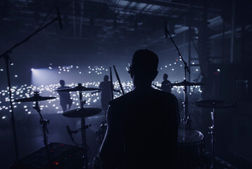 Music band group silhouette perform on a concert stage.  
silhouette of drummer playing on...