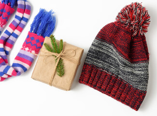 winter hat,  gift box and multicolored knitted scarf on a white background,