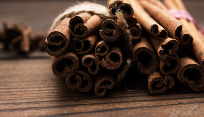 tied bunch of brown cinnamon sticks on a wooden background