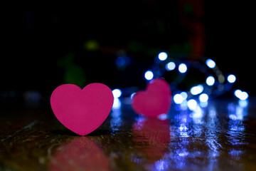 pink heart on rustic wood with defocused heart and lights background. Valentine's Day.