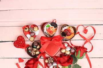 Delicious cupcakes with roses, candies and gift boxes, food for valentine's day or women's day, greeting card with place for text, top view, banner for shop advertisement or invitation, 