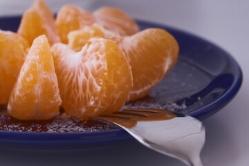 Orange clementines ready to be eaten. Orange fruit, fresh and natural. Fruit with or without sugar. Clementines in blue dishes.
