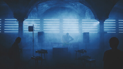 DJ playing on party under arch in ancient abandoned building 