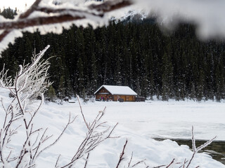 Winter view of a wooden cabin surrounded by snow at Lake Louise, Canada