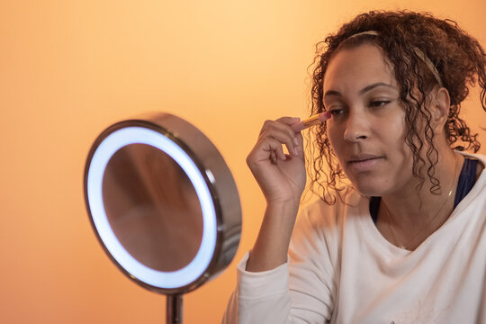 ethnic woman using beauty and make up products in front the mirror,