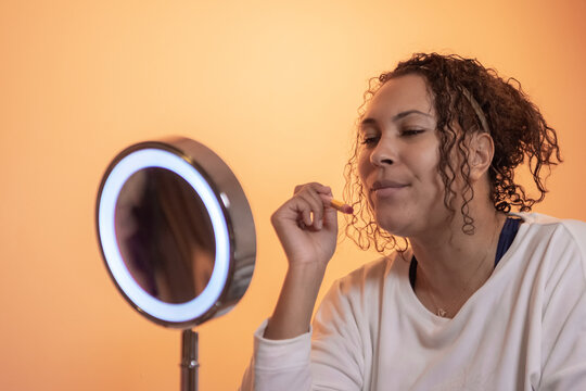 ethnic woman using beauty and make up products in front the mirror,