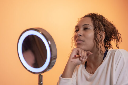ethnic woman using beauty and make up products in front the mirror,