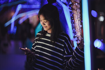Asian young girl using a mobile phone in downtown